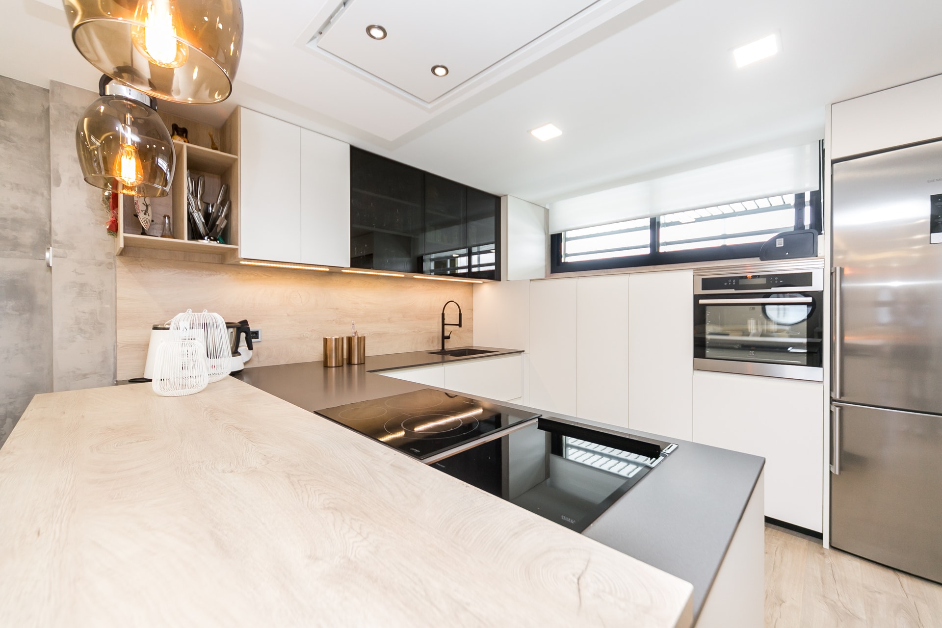 Cocina blanca con encimera de madera y columnas de horno