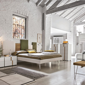 Un Dormitorio Moderno Con Paredes Blancas Y Suelos De Madera Diseñado Por Un Interiorista En Badalona.